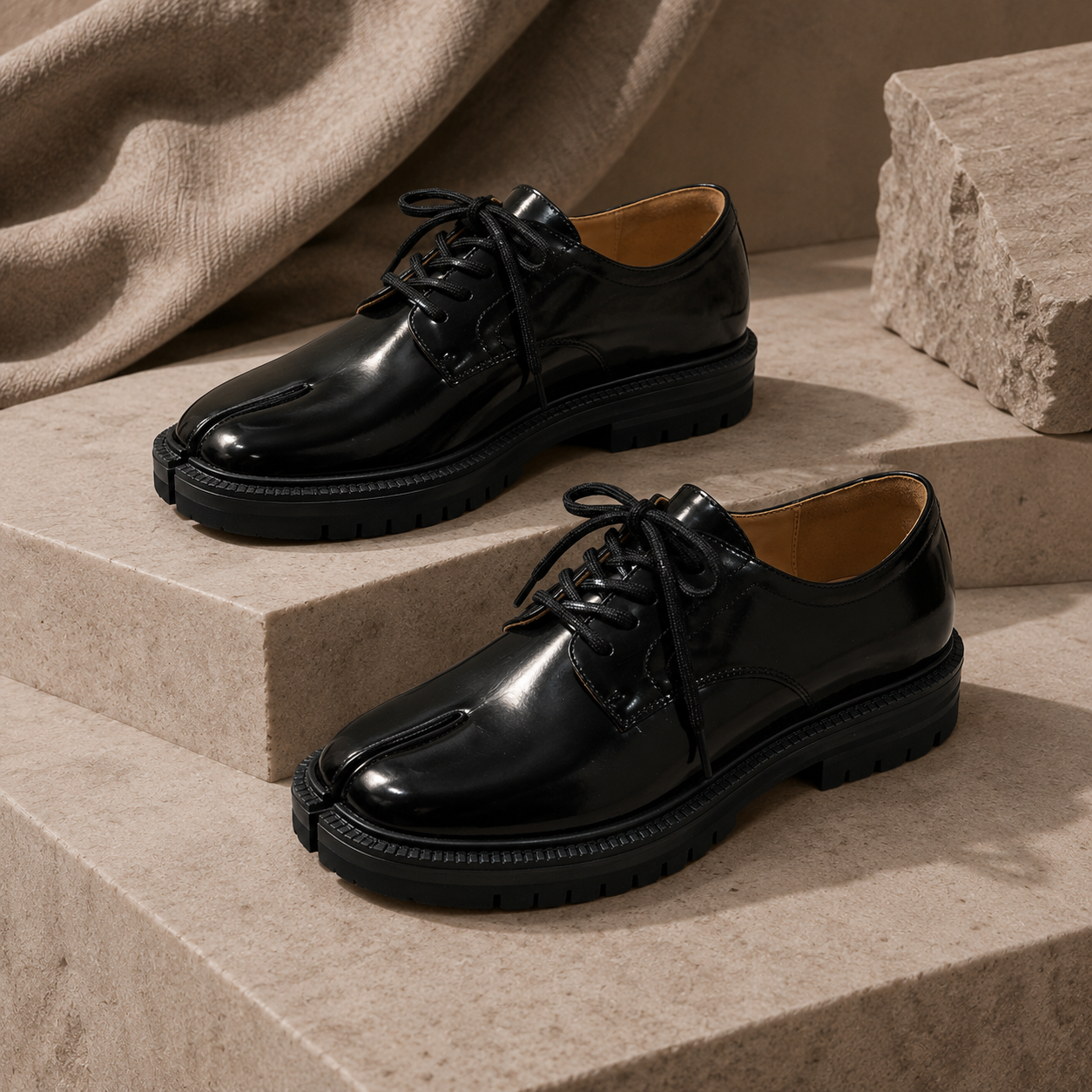 Black glossy split-toe lace-up leather flats on stone display